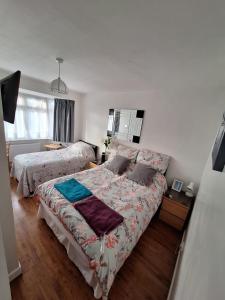 a bedroom with two beds and a window at Harrow B & B in Harrow Weald