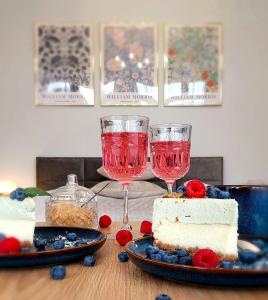 a table with two wine glasses and a piece of cake at Tullu Apartament - w centrum, blisko bulwaru, blisko molo in Ostróda