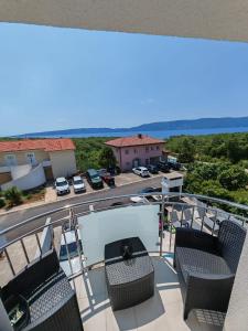 ein Balkon mit Stühlen und Blick auf einen Parkplatz in der Unterkunft Villa Infinity in Krk