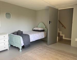 a small bedroom with a bed and a dresser at 102 Vyfer, De Kelders in De Kelders