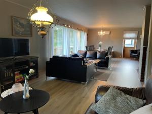a living room with a couch and a tv at Kyrkjeneset in Bjerkreim