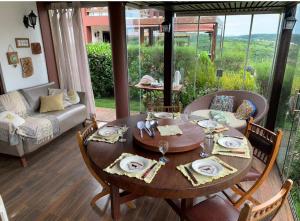 a dining room table with chairs and a table and a couch at Chalé Nevada 310 in Bananeiras
