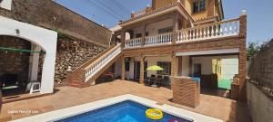 a house with a swimming pool in front of a house at UF holiday Villa in Málaga