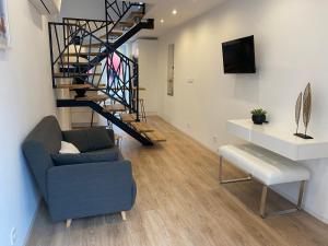 a living room with a blue couch and a staircase at Maison cosy in Mauzé-sur-le-Mignon