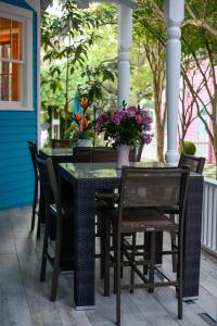 a table and chairs on a porch with purple flowers at 5 BR - Sleeps 8! Steps from Bourbon Street! in New Orleans