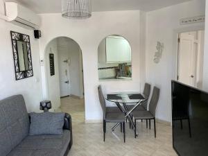 ein Wohnzimmer mit Tisch und Couch in der Unterkunft Luxury beach apartment in Torrevieja