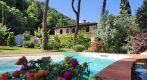 a house with a swimming pool in front of a yard at Villa La Ginestra - Charming Country Home in Capolona