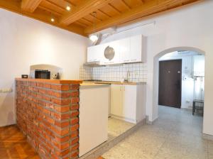 a kitchen with a brick wall and white cabinets at Charming Apartment - Heart of Brașov Poarta Schei in Braşov +7 photos