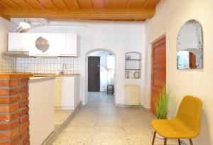 a kitchen with white cabinets and a yellow chair at Charming Apartment - Heart of Brașov Poarta Schei in Braşov
