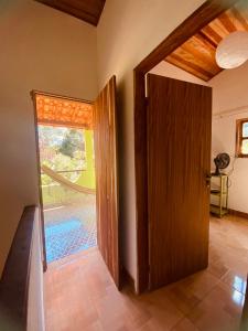 une porte ouverte sur une pièce avec une piscine à l'extérieur dans l'établissement O galpão Casa Flor, à Vale do Capão
