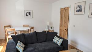 a living room with a black couch and a table at Casa Ballycastle Town Centre in Ballycastle
