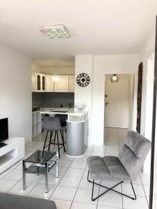 a living room and kitchen with a couch and a table at FLEUR De LYS - PROCHE CENTRE VILLE ET LAC in Thonon-les-Bains
