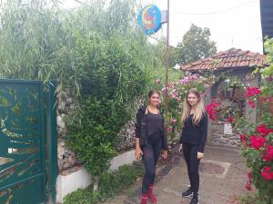 two women standing next to a wall with flowers at Victoriei 35B in Curtea de Argeş