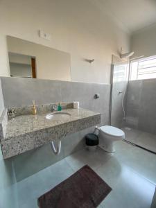 a bathroom with a sink and a toilet at Pousada Pôr Do Sol Varginha in Varginha