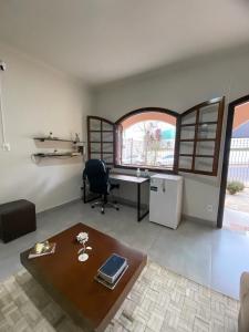 a living room with a desk and a table at Pousada Pôr Do Sol Varginha in Varginha +35 photos