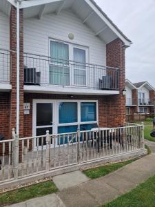 a house with a white fence and a balcony at clifftop villa 47 in Corton