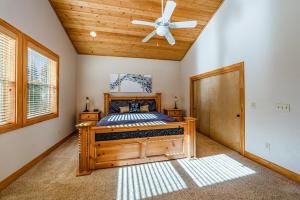 ein Schlafzimmer mit einem Bett mit Deckenventilator in der Unterkunft Sierra Pines Villa Deck Jetted Tub Game Rm in Shaver Lake