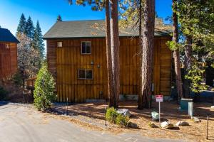 eine große Holzhütte mit Bäumen davor in der Unterkunft Sierra Pines Villa Deck Jetted Tub Game Rm in Shaver Lake