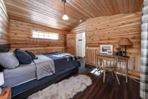 una camera da letto in stile baita di tronchi con letto e scrivania di The Cedar House Prime Spot Kayaks & Cool Ac a Shaver Lake