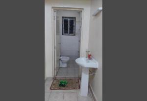 a bathroom with a white sink and a toilet at Little Haven Nyali mombasa in Mombasa +66 photos