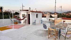 une terrasse avec des chaises et une table sur une maison dans l'établissement Appartement vue sur mer SOUL FAMILY, Egine, à Égine