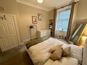 a bedroom with a white bed and a window at West Dunbartonshire Flat, near Loch Lomond in Dumbarton