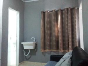 a bathroom with a sink and a window with curtains at Apto 11 bom preço benefício in Brasilia +6 photos