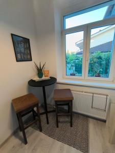 a table and two stools in a room with a window at Apartmán Pohoda Zvolen in Zvolen
