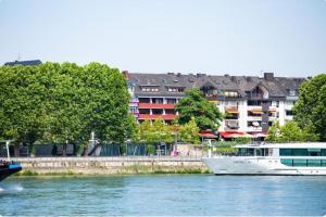 a boat on the water with buildings in the background at Apartment mit Balkon am Rhein in Koblenz