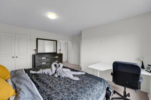 Un dormitorio con una cama, un escritorio y una silla. en Spacious Family Friendly Vacation home, en Brampton