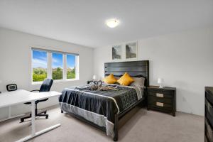 un dormitorio con una cama y un escritorio en Spacious Family Friendly Vacation home, en Brampton