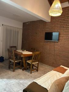 Un comedor con mesa y sillas y un televisor. en La Florida Departamentos, en Jesús María