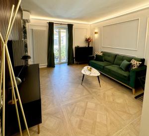 a living room with a green couch and a table at Cloè Boutique Apartment in Termoli