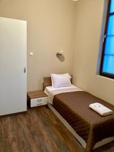a small bedroom with a bed and a window at Balkan Aparts in Hisarya