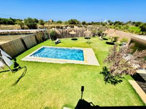 a backyard with a swimming pool in the grass at DAR MAÏSSA in Asilah