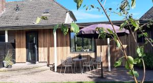 a patio with a table and chairs and an umbrella at 't Holtslag in Baak
