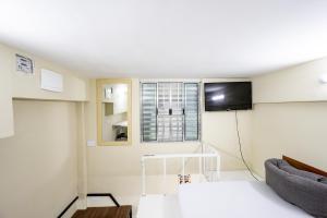 ein Wohnzimmer mit Couch und Fernseher in der Unterkunft Pousada com Banheiro Privativo Proximo a Expo e Metro in São Paulo