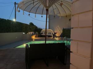 a patio with an umbrella and a swimming pool at Hotel Kourkoumelata in Argostoli