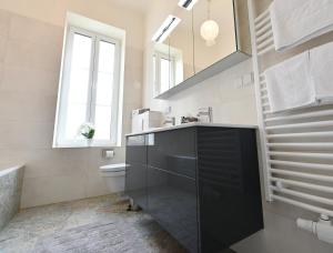 Villa Gloriette - BoutiqueAppartements am Wörthersee في بويرشاك آم فورثيرسي: حمام مع حوض ومرحاض ومرآة +62 صورة