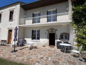a patio with chairs and tables in front of a house at Belle Maison avec vue magnifique , séjour pleine nature gd jardin in Cressat