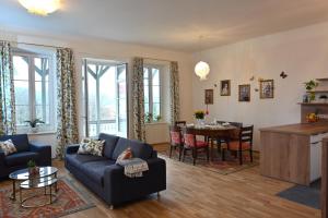 Villa Gloriette - BoutiqueAppartements am Wörthersee في بويرشاك آم فورثيرسي: غرفة معيشة مع أريكة زرقاء وطاولة