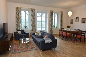 Villa Gloriette - BoutiqueAppartements am Wörthersee في بويرشاك آم فورثيرسي: غرفة معيشة بها أريكة وطاولة