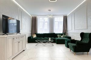 a living room with a green couch and a tv at Tamanska Luxury Apartments in Lviv