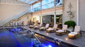 a lobby with a pool and chairs and a table at Gran Hotel de Puebla by HNF in Puebla