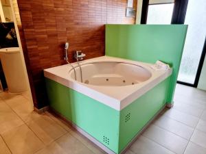 a green and white bath tub in a room at Apartamentos El Arrecife in Conil de la Frontera