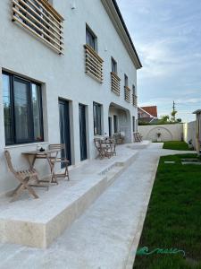 a patio with a table and benches next to a building at Muse 2Mai in 2 Mai