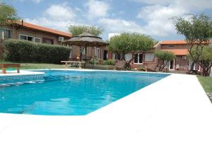 a swimming pool in front of a house at Hosteria Amaneseres in Capilla del Monte