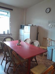 a red table and chairs in a kitchen with a refrigerator at Guesthouse in Ólafsvík
