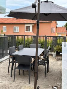 a table and chairs under an umbrella on a patio at Apartma Hany in Koper