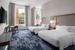 een hotelkamer met twee bedden en een televisie bij Fairfield Inn & Suites Madison Historic Eagle Cotton Mill in Madison +77 foto's